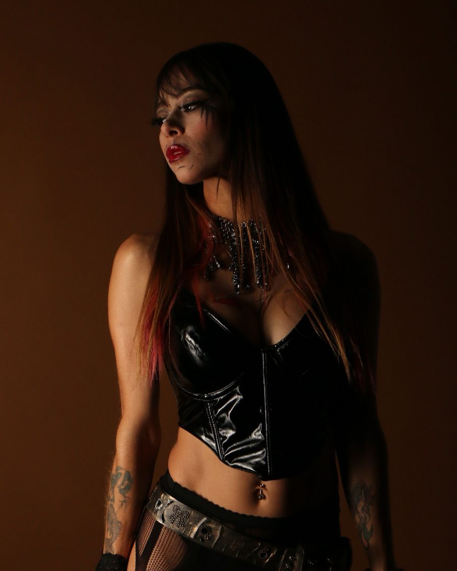 Femme en corset de cuir noir dans un studio sombre