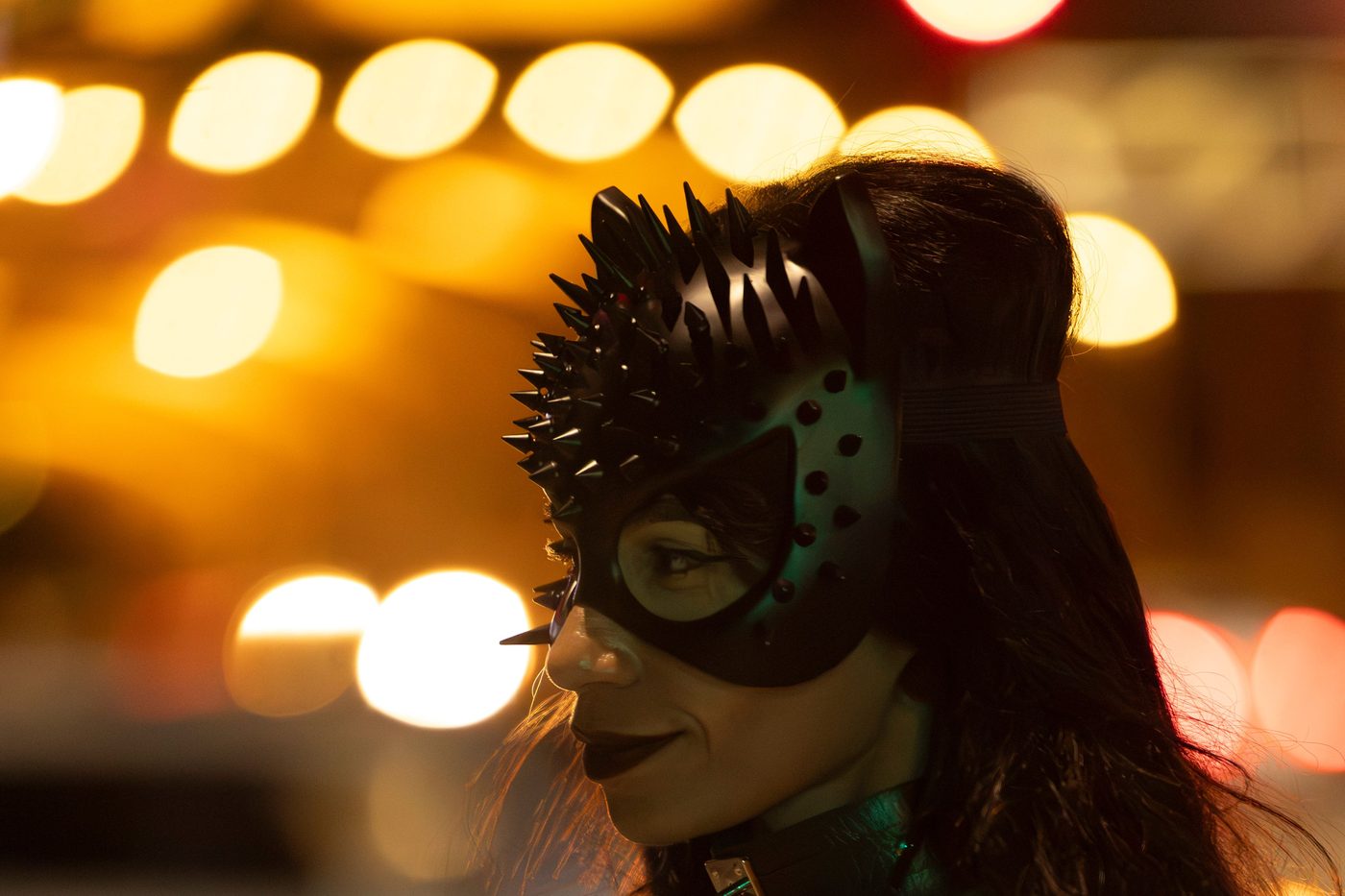 Femme avec masque de chat et lumières nocturnes de ville